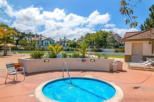 view of pool with a hot tub and a patio