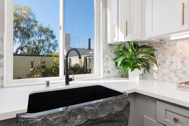 details with sink, backsplash, and white cabinets