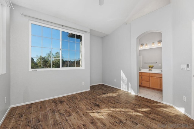 unfurnished bedroom with ensuite bath and light wood-type flooring