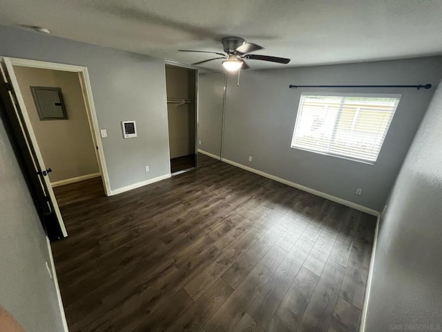 unfurnished bedroom featuring ceiling fan, dark hardwood / wood-style floors, and a closet