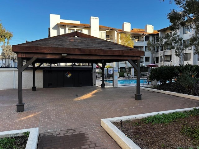 view of vehicle parking featuring a gazebo and a community pool