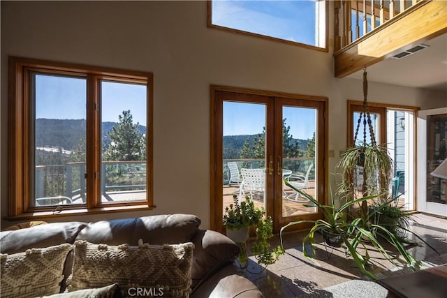 interior space with a healthy amount of sunlight, a mountain view, and french doors