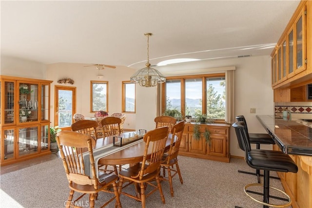 dining room featuring light carpet and a notable chandelier