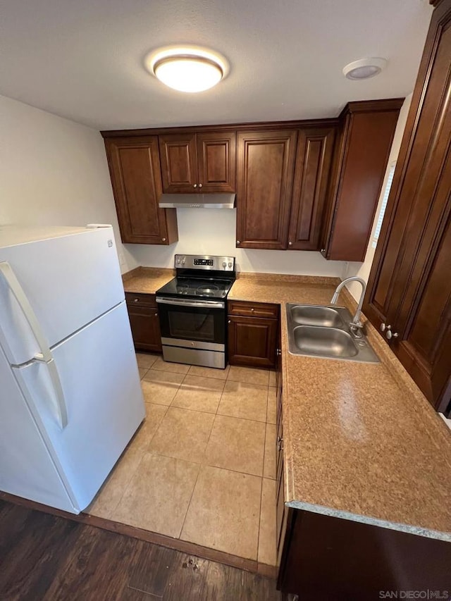 kitchen with stainless steel range with electric cooktop, white refrigerator, light hardwood / wood-style flooring, and sink