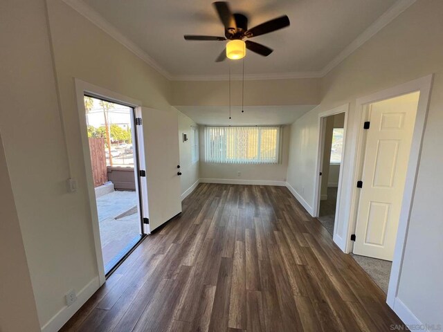 unfurnished dining area featuring ceiling fan, dark wood-type flooring, and crown molding