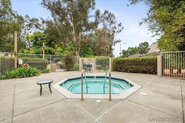 view of swimming pool featuring a hot tub and a patio