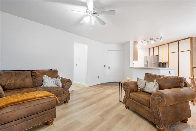 living room featuring ceiling fan and light hardwood / wood-style flooring