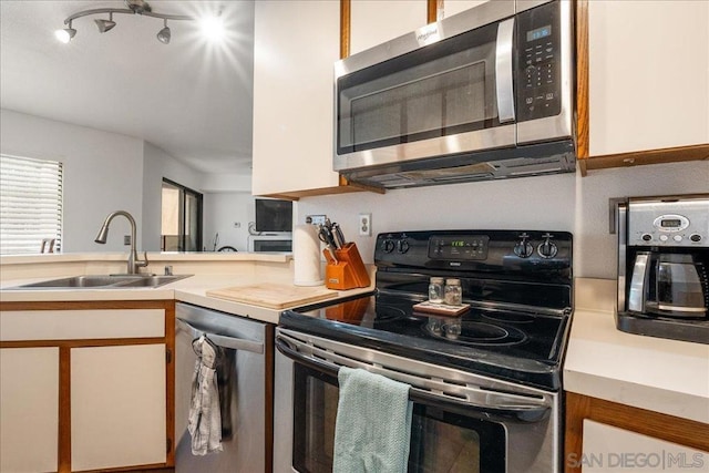 kitchen featuring sink, white cabinets, and stainless steel appliances