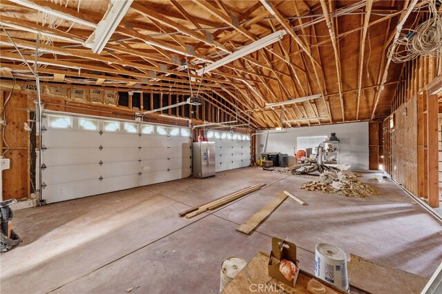 garage with stainless steel fridge and water heater