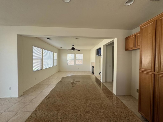 unfurnished living room featuring ceiling fan and light tile patterned floors