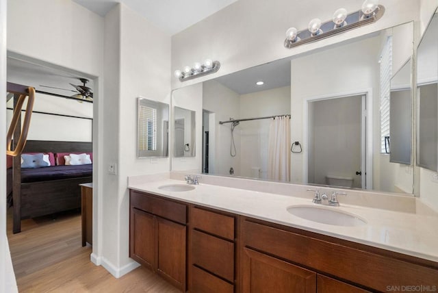 bathroom with toilet, hardwood / wood-style floors, ceiling fan, a shower with shower curtain, and vanity