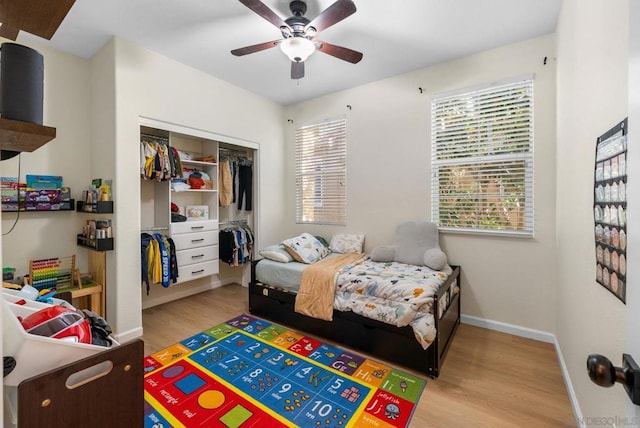 bedroom featuring ceiling fan, a closet, and light hardwood / wood-style flooring