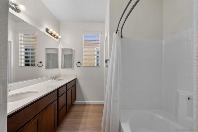 bathroom with shower / bathtub combination with curtain, hardwood / wood-style floors, and vanity