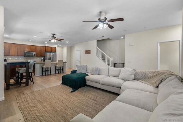 living room featuring light hardwood / wood-style floors and ceiling fan