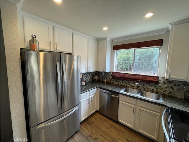 kitchen with white cabinets, decorative backsplash, appliances with stainless steel finishes, and sink