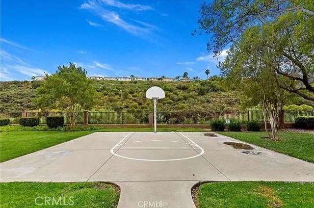 view of sport court featuring a lawn