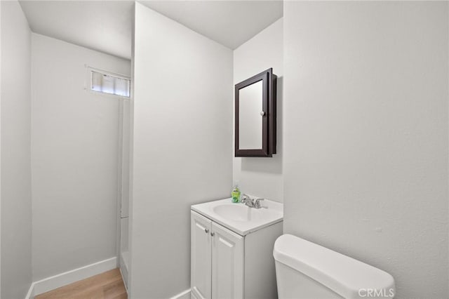 bathroom featuring toilet, hardwood / wood-style floors, and vanity