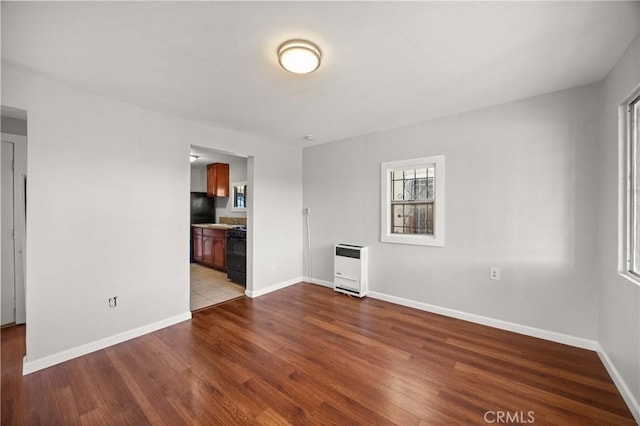 unfurnished living room with hardwood / wood-style flooring and heating unit