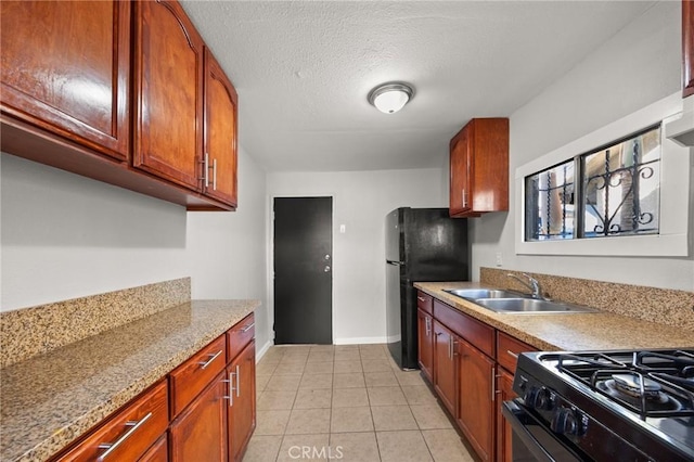 kitchen featuring black appliances, light tile patterned floors, sink, and a textured ceiling