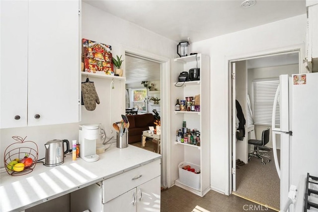 interior space featuring dark carpet, white cabinets, and white fridge