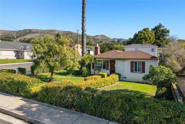 ranch-style house featuring a front lawn and a mountain view