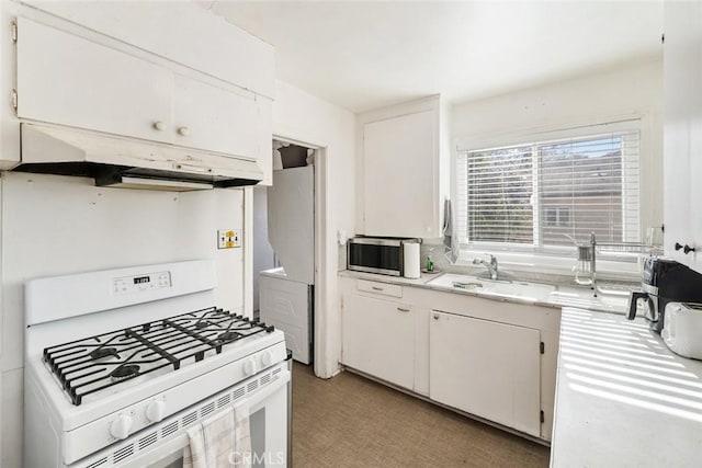 kitchen with white cabinetry, white gas range, and sink