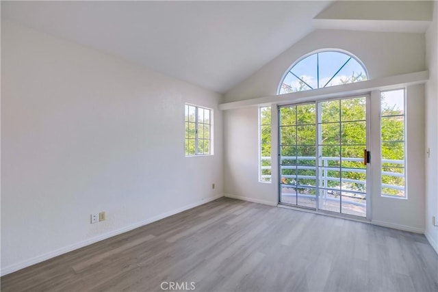 unfurnished room featuring vaulted ceiling and wood-type flooring