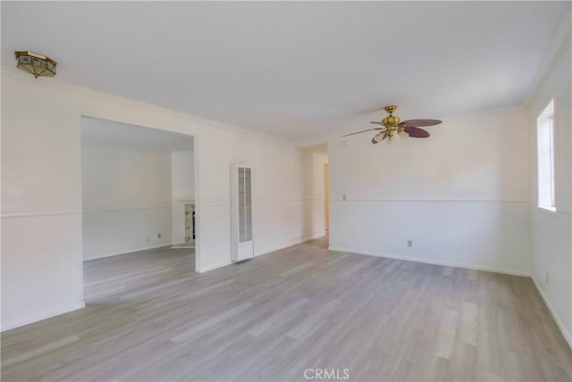 empty room featuring ceiling fan, ornamental molding, and light wood-type flooring