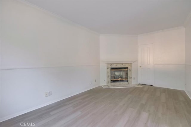 unfurnished living room with a fireplace, crown molding, and light hardwood / wood-style floors