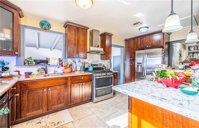 kitchen featuring wall chimney range hood, sink, appliances with stainless steel finishes, backsplash, and hanging light fixtures