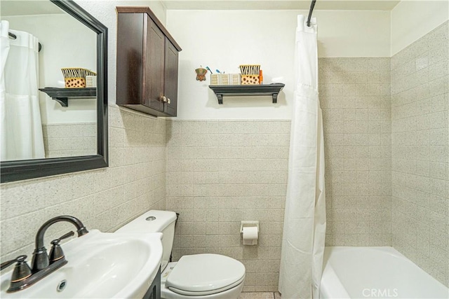 full bathroom featuring shower / bath combo with shower curtain, toilet, sink, and tile walls