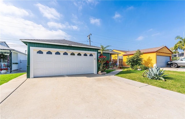 ranch-style home with a front yard, a garage, and an outdoor structure