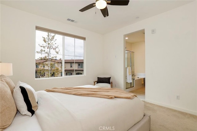 bedroom with light carpet, ceiling fan, and ensuite bath