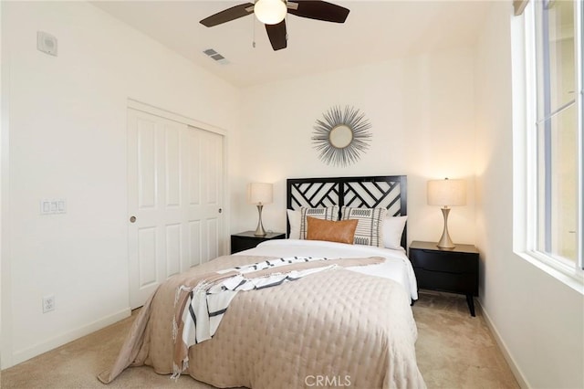 bedroom with light carpet, ceiling fan, and a closet