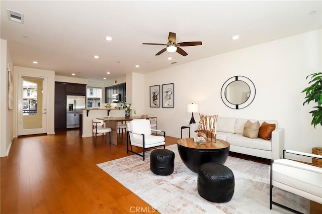 living room with ceiling fan and dark hardwood / wood-style flooring