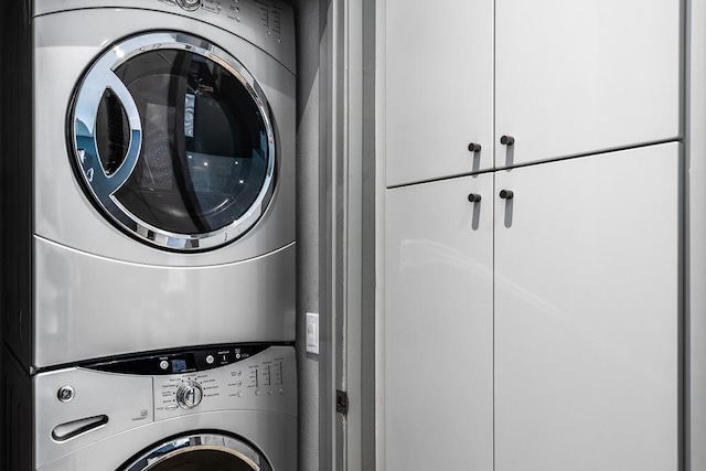 clothes washing area featuring stacked washer / dryer