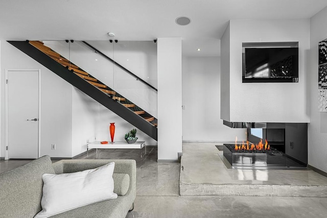 living room with a multi sided fireplace and concrete flooring