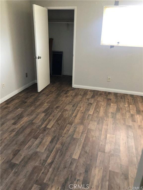 unfurnished bedroom featuring dark hardwood / wood-style floors and a closet