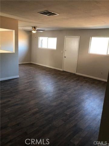 spare room featuring ceiling fan and dark hardwood / wood-style floors