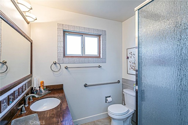 bathroom featuring toilet, tile patterned floors, a shower with door, and vanity