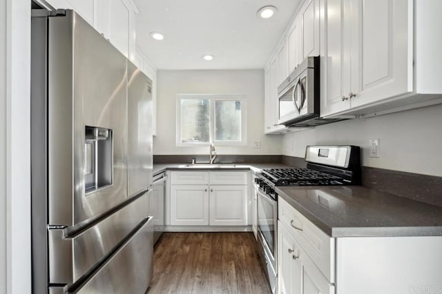 kitchen with dark wood-type flooring, white cabinetry, and stainless steel appliances