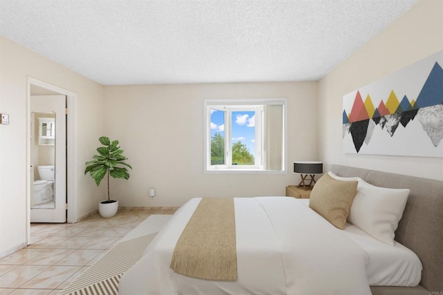 bedroom featuring connected bathroom, light tile patterned floors, and a textured ceiling