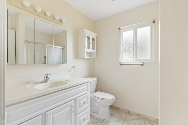 bathroom featuring tile patterned flooring, vanity, toilet, and walk in shower