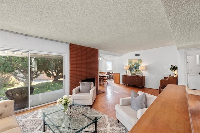 living room with a textured ceiling, hardwood / wood-style floors, and plenty of natural light