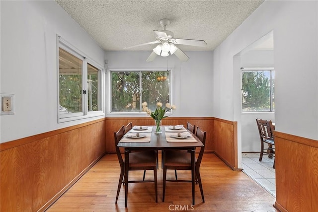 dining space featuring ceiling fan, a textured ceiling, and light hardwood / wood-style flooring