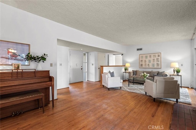 living room featuring wood-type flooring and a textured ceiling