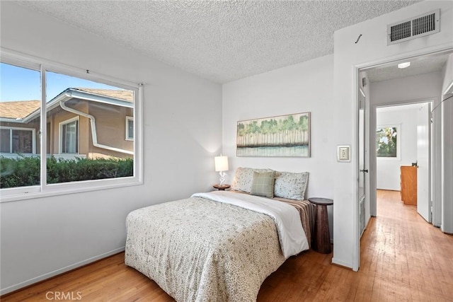 bedroom featuring hardwood / wood-style flooring and a textured ceiling