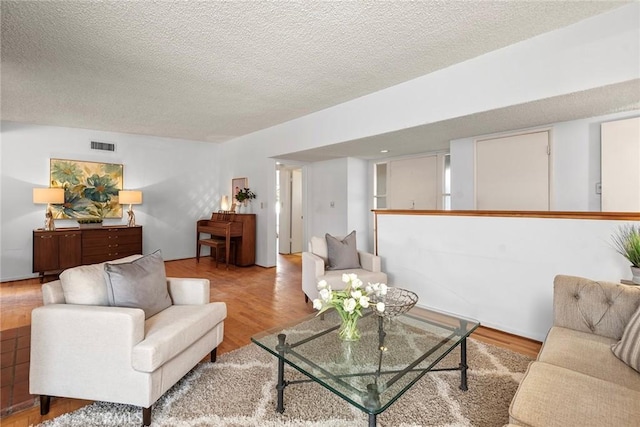 living room featuring a textured ceiling and light hardwood / wood-style flooring