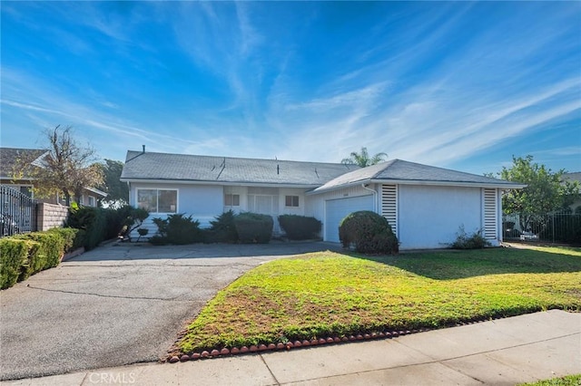 ranch-style house featuring a garage and a front lawn