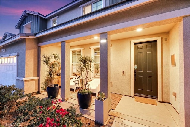 exterior entry at dusk featuring a garage